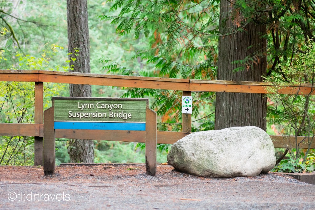 A sign directs travelers to Lynn Canyon Suspension Bridge in North Vancouver